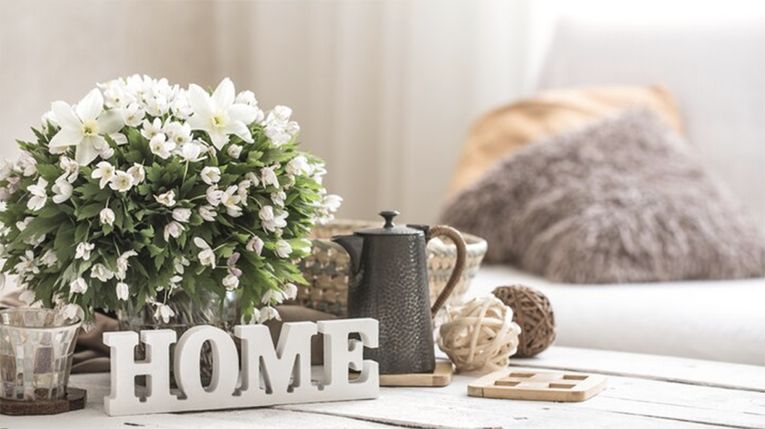 table with flowers and a home sign